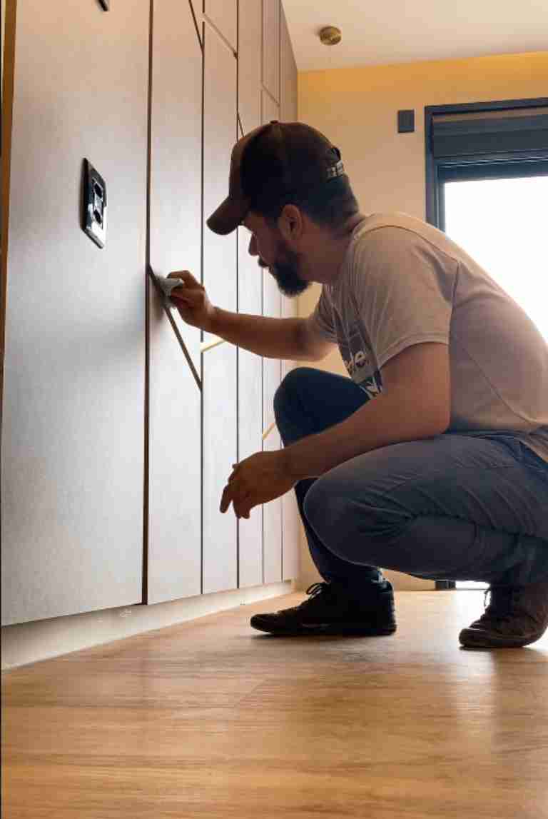 Vinicius trabalhando no ajuste de portas de um móvel planejado